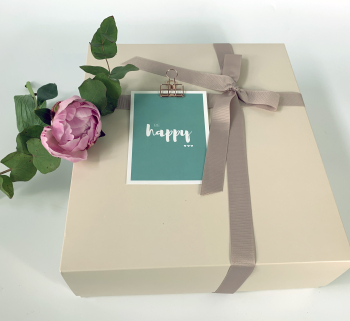 Beige gift box with ribbon and floral decoration