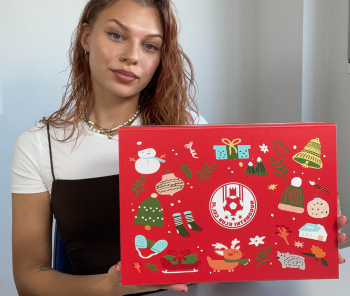 Person holding a Christmas-decorated cardboard gift box