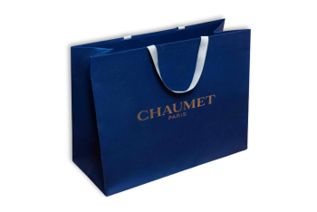 Blue paper bag with golden lettering and white handles