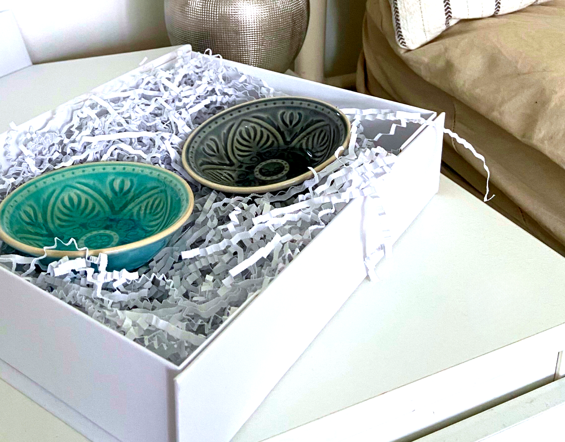Two ceramic bowls in a white gift box with protective filling material