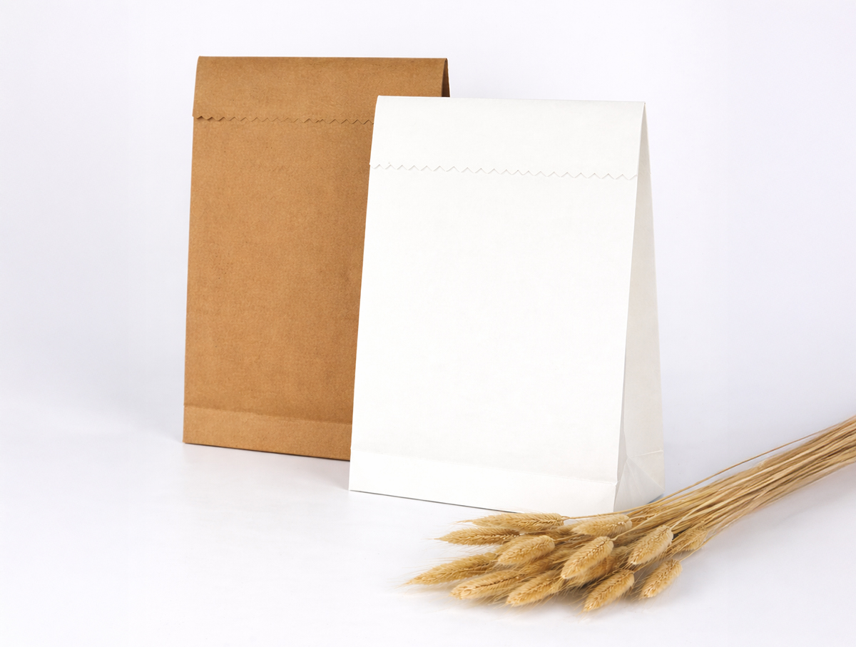 Two paper bags, one brown and one white, next to dried flowers